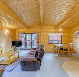 A living room with a sofa and dining table at Maple Lodge in Louth
