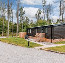 A cabin exterior with steps and gravel path at Anderby Spa (Pet) Louth