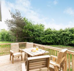 A deck with wooden furniture and greenery at Caistor Spa in Louth
