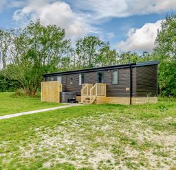 A house with a deck and steps surrounded by grass at Horncastle Plus in Louth