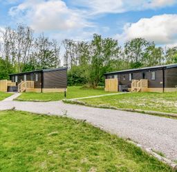 Two lodges with a pathway in an outdoor area at Horncastle Plus in Louth