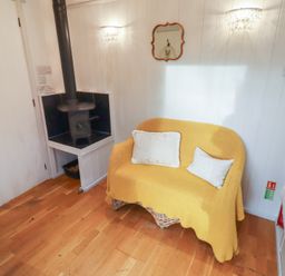 A snug with a sofa and wood stove at Meadows in Hexham