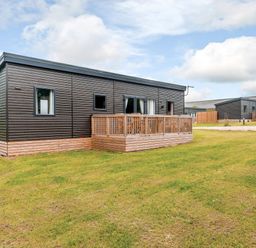 A lodge with decking and grass area at The Kinder Spa (Pet) Louth