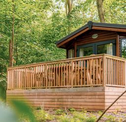 A cabin with a wooden deck and outdoor seating at Alford Spa (Pet) Louth