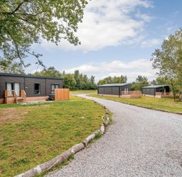 Three cabins along a gravel path at Horncastle Spa Plus (Pet) in Louth