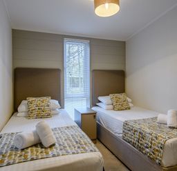 A bedroom with two beds and a nightstand at Stamford Spa (Pet) in Louth