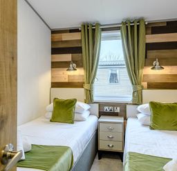 A bedroom with two single beds and a nightstand at Elsham Lodge (Pet) Louth
