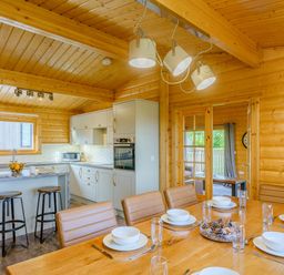 A kitchen with a dining area and bar stools at Hazel Lodge in Louth