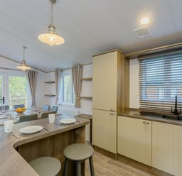 A kitchen with a dining table and bar stools at Brayford Lodge in Louth