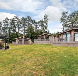 Several wooden lodges and a gazebo on grass at Retreat Lodge 4 in Louth