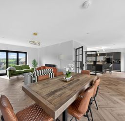 A living room with a dining table and chairs at Heddfan in Carmarthen