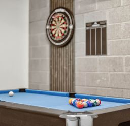 A game room with a pool table and dartboard at Heddfan in Carmarthen