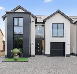 A modern house with a garage and large windows at Ty Uchel 