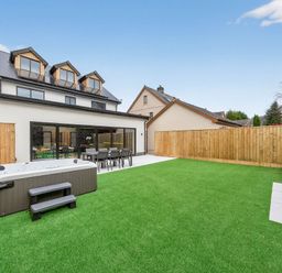 A garden with a hot tub and dining set at Ty Uchel in 
