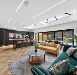 A living room with a kitchen island and dining area at Ty Uchel 