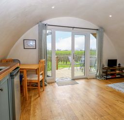 A living room with a table and chairs at Grape Escape near Halesworth