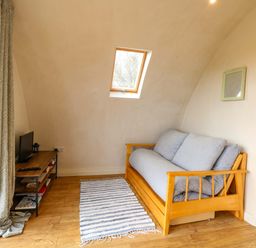 A living room with a sofa and a television at Grape Escape near Halesworth