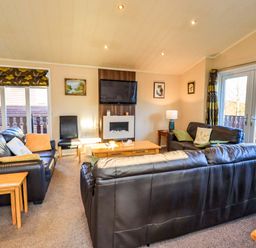 A living room with a sofa and coffee table at Kingfisher Lodge
