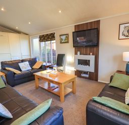 A living room with a television and coffee table at Kingfisher Lodge