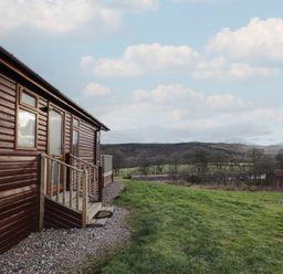 A lodge with a deck and surrounding landscape at Colonsay