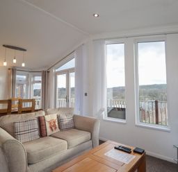 A living room with sofa, coffee table and large windows at Colonsay