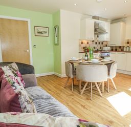 A kitchen area with a dining table and chairs at Rodwell Holt in Weymouth
