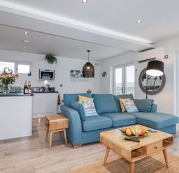 A living room with a blue sofa and a coffee table at Adelaide in Portreath