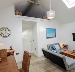 A living room with a sofa and table at Cove Retreat in Penzance