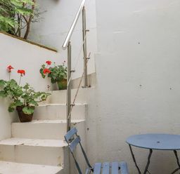 A staircase with plants and a table and chair at Cove Retreat in Penzance