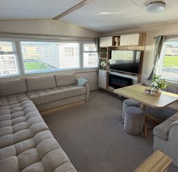 A living room with a sofa and coffee table at The Beachside Hideout - St Michaels Caravan Park Towyn