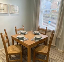 A dining room with a table and chairs at Snugglers Cove in Dartmouth
