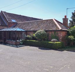 A house with a conservatory and garden at Winston Lodge in Beccles