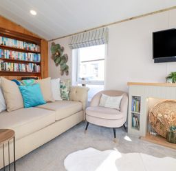 A living room with a sofa and bookshelf at FW4 (Fairways 4)