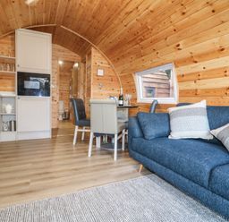 A combined living and kitchen area with a sofa and dining table at Park View Lodge