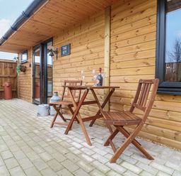 An outdoor seating area with table and chairs at The Sty in Hatton, Derbyshire