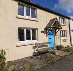 A house with a blue door and bench at 1 Mill Farm Cottages Narberth