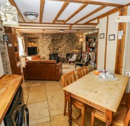 A kitchen with dining table and sofa at 1 Mill Farm Cottages in Narberth
