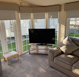 A living room with a television and sofa at Gainc Bach in Abergele