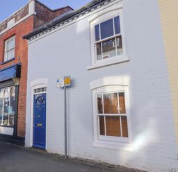 A building with a blue door and windows at Rope Cottage in Bridport