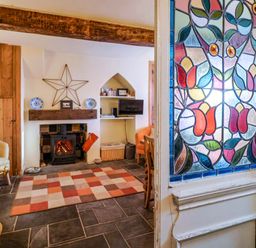 A living room with a fireplace and tv at Rope Cottage in Bridport