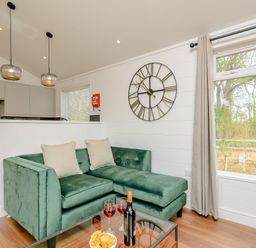 A living room with a green sofa and table at The Castor in Kings Cliffe