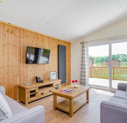 A living room with a television and sofa at The Kingscliffe (Pet) in Kings Cliffe