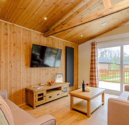 A living room with a television and coffee table at The Sutton in Kings Cliffe