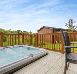 A hot tub and chairs on a deck at The Nassington (Pet) in Kings Cliffe