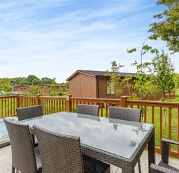 A dining table with chairs on a deck at The Nassington (Pet) Kings Cliffe