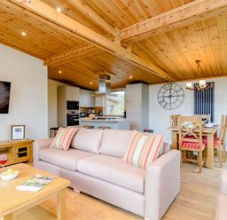 A living room with a sofa and dining area at The Wansford in Kings Cliffe
