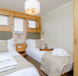 A bedroom with two beds and a tray with cups at The Ailsworth (Pet) in Kings Cliffe