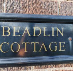 A plaque with the words Beadlin Cottage at Beadlin cottage Beadnell