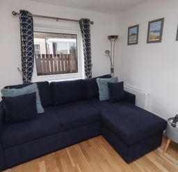 A living room with a sofa and decorative items at Beadlin cottage Beadnell