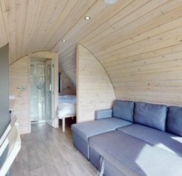 A pod with a sofa, shower, bed, and table at Pod 1 (Pet Friendly) Carnforth